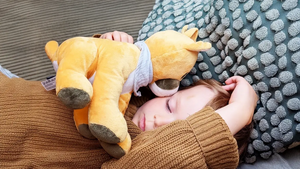 Lenabo Hörspiel Kuscheltier im Einsatz, Kind schläft entspannt mit Lenabie Tali Puma und hört beruhigende Audios, Wiedergabe über die Lenabo App steuerbar für Weißes Rauschen, Einschlafmelodien, Gute-Nacht-Geschichten und Hörspiele für Kinder von 0–7 Jahren